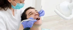 Dentista preparando los dientes de paciente antes de colocar carillas dentales